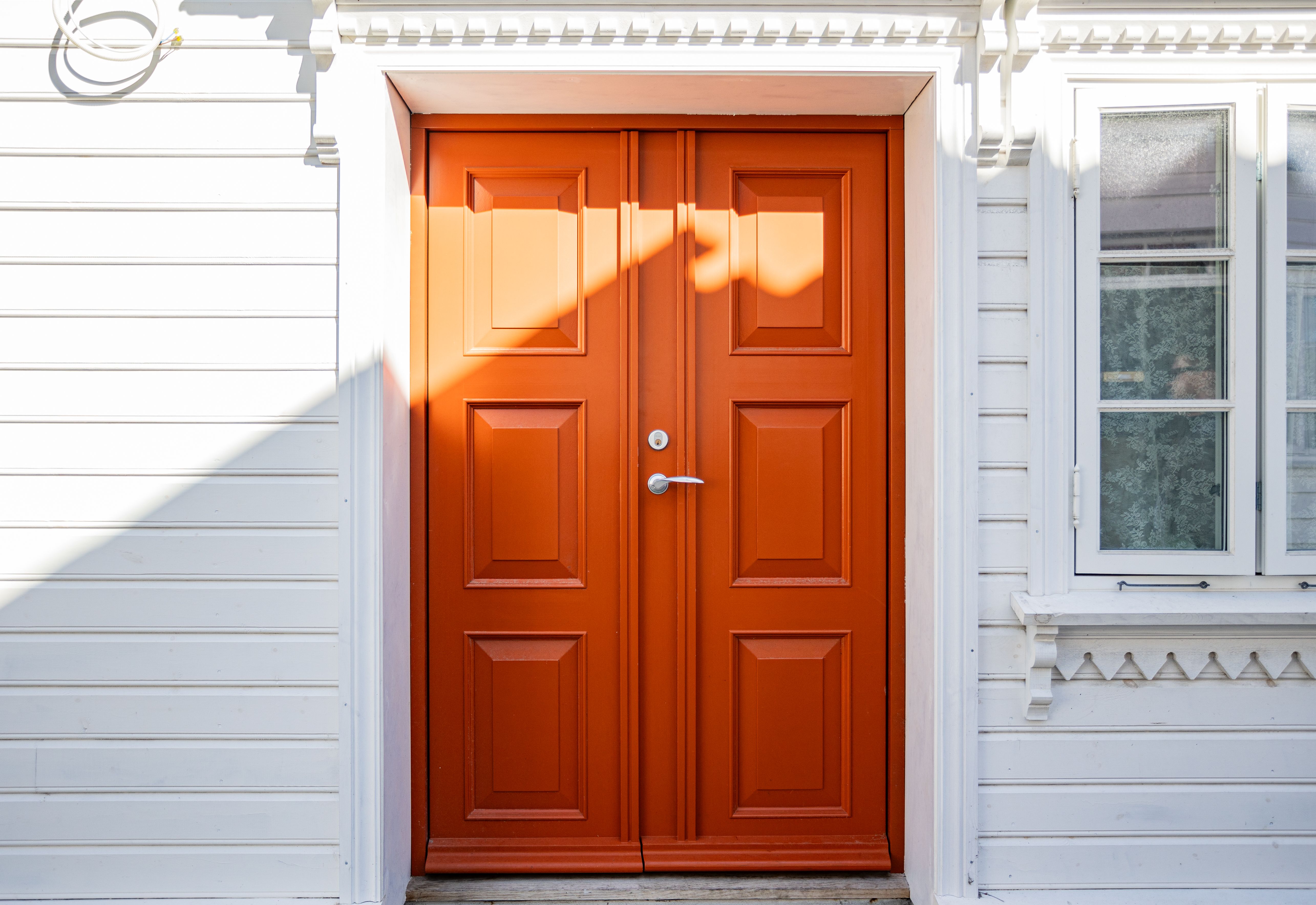 White home exterior with orange front door